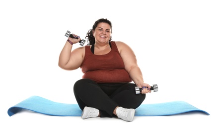 Photo of Overweight woman with mat and dumbbells on white background