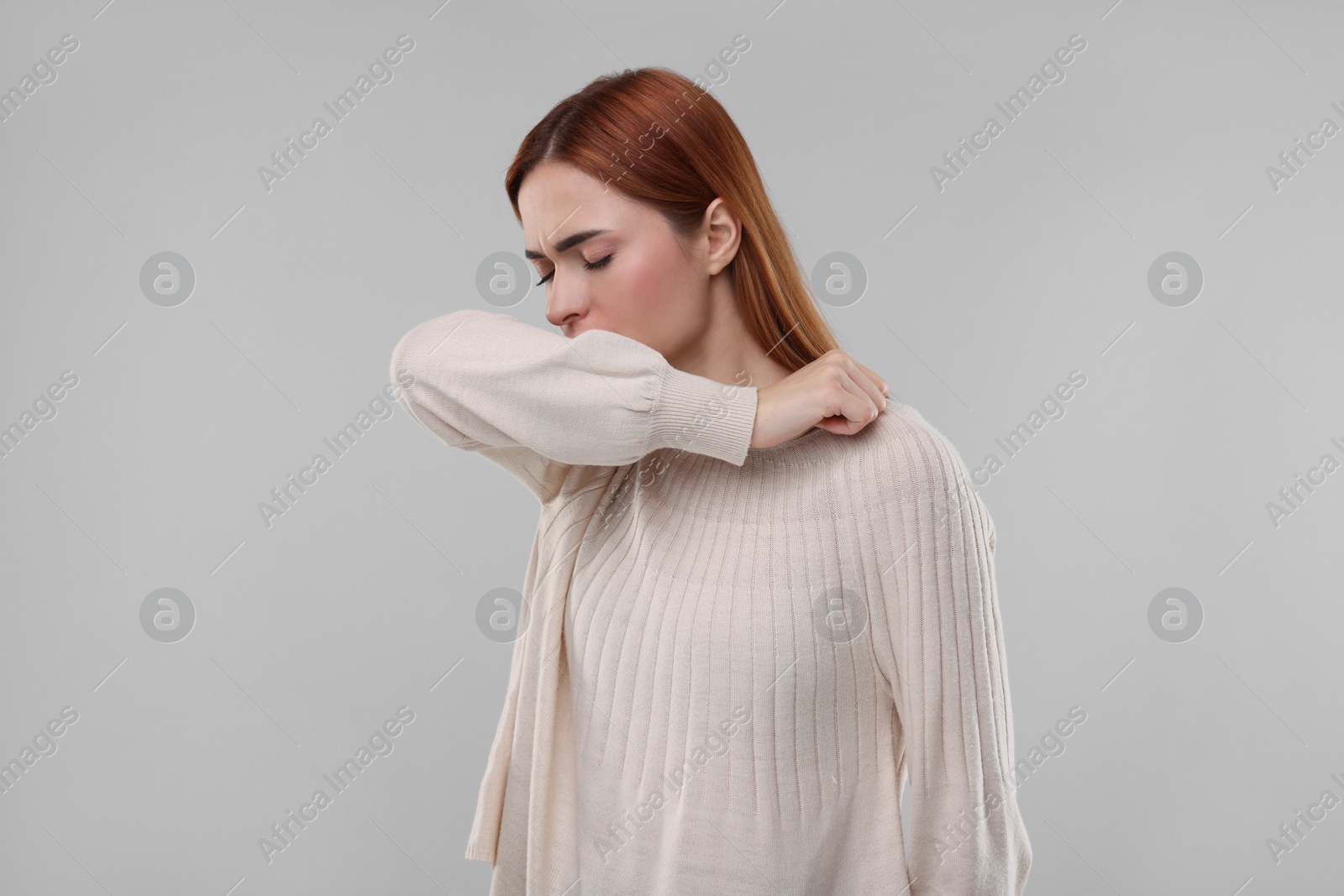 Photo of Woman coughing on light grey background. Cold symptoms