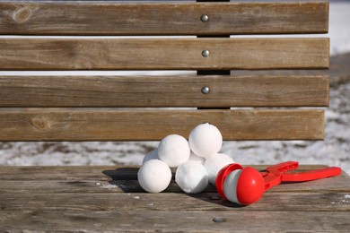 Snowballs and plastic tool on bench outdoors