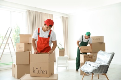 Photo of Male movers with boxes in new house