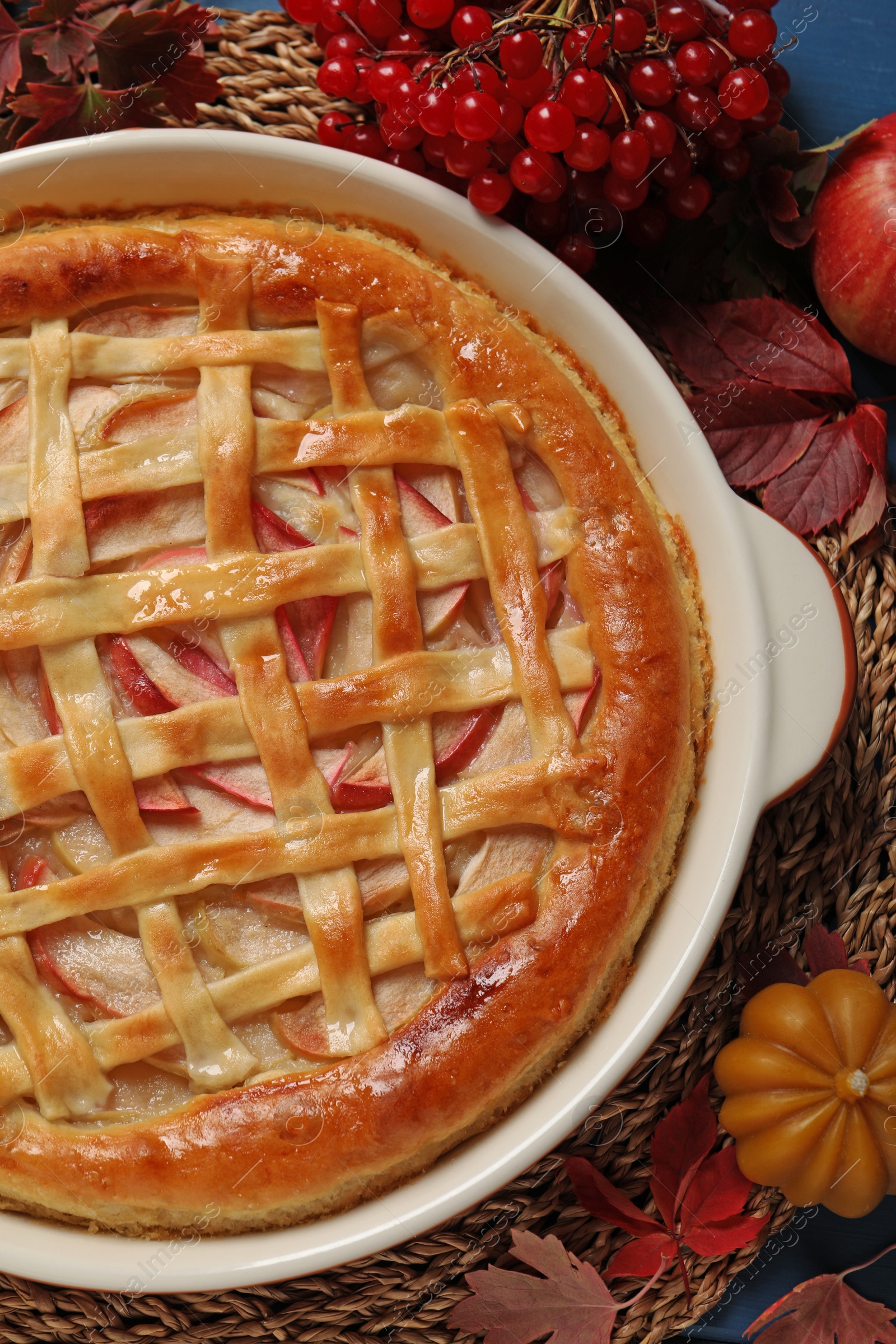 Photo of Delicious homemade apple pie and autumn decor on blue wooden table, flat lay. Thanksgiving Day celebration