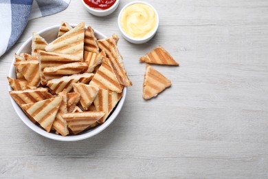 Photo of Delicious pita chips on white wooden table, flat lay. Space for text