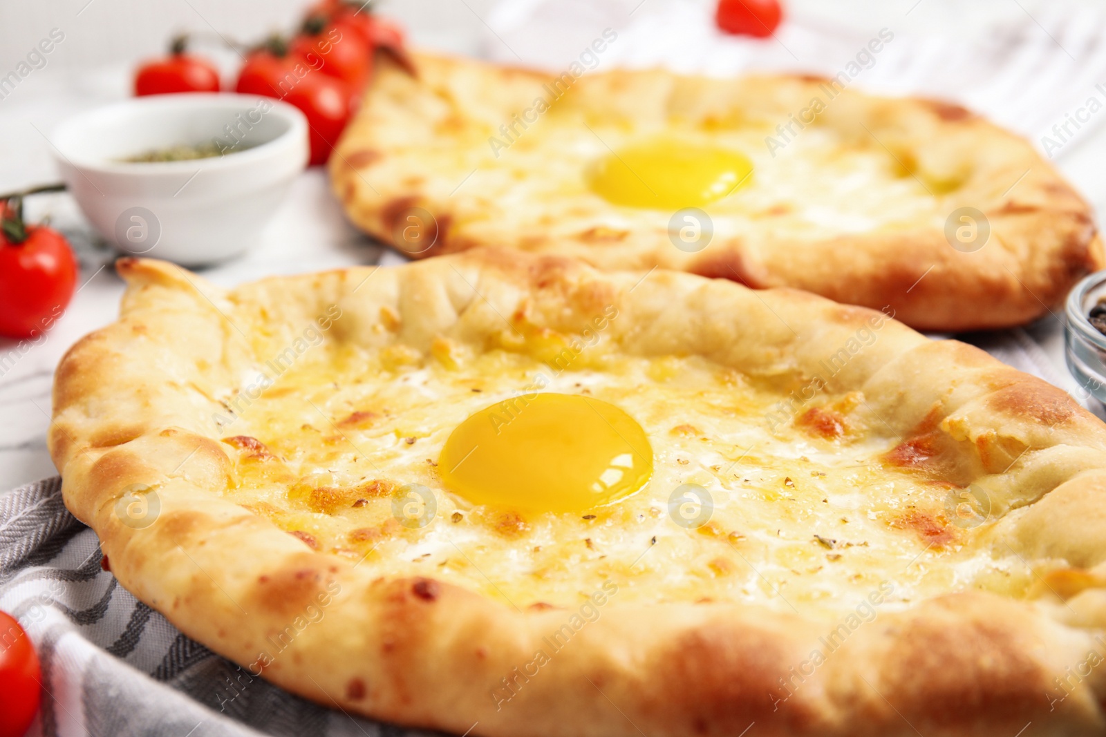 Photo of Fresh delicious Adjarian khachapuris on table, closeup