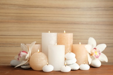 Photo of Beautiful composition with lit candles and flowers on table