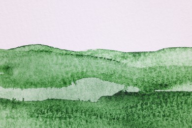 Photo of Abstract green watercolor painting on white paper, top view