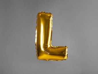 Photo of Golden letter L balloon on grey background