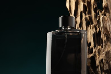 Photo of Luxury men`s perfume in bottle against color background, space for text
