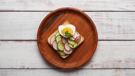 Photo of Tasty sandwich with boiled egg, radish and cucumber on white wooden table, top view