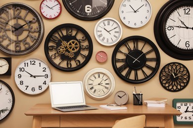 Collection of wall clocks over workplace indoors