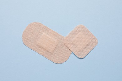 Photo of Contraceptive patches on light blue background, flat lay