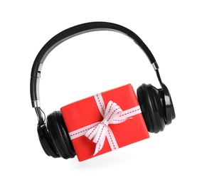 Photo of Gift box with headphones isolated on white. Christmas music concept
