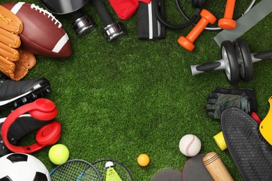 Photo of Frame of different sports equipment on green grass, flat lay. Space for text