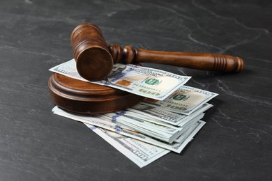 Photo of Judge's gavel and money on dark grey table