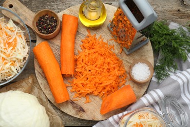 Photo of Cooking delicious sauerkraut soup. Fresh chopped carrot and ingredients on old wooden table, flat lay