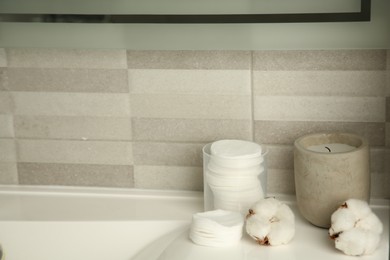Photo of Cotton pads and flowers on sink indoors, space for text