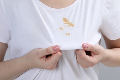 Photo of Woman showing stain on her t-shirt, closeup