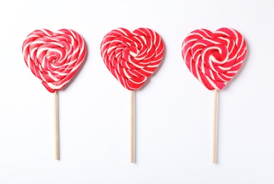Photo of Sweet heart shaped lollipops on white background, flat lay. Valentine's day celebration