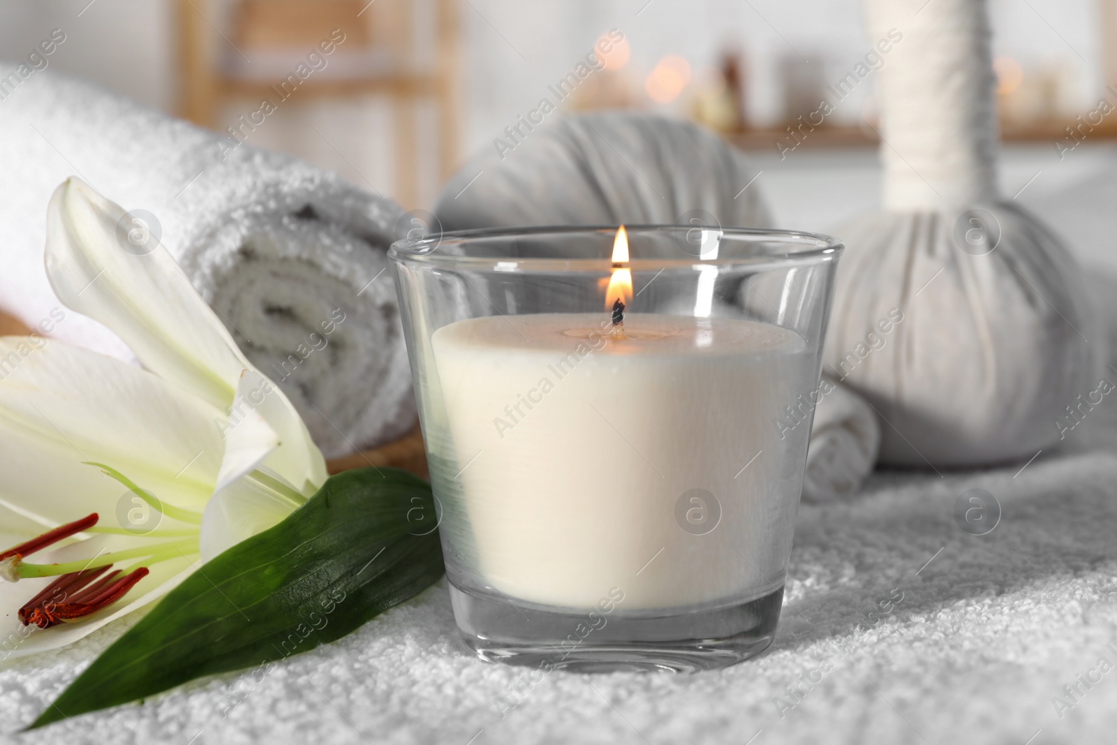 Photo of Spa composition with burning candle and herbal bags on massage table in wellness center