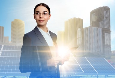 Image of Double exposure of businesswoman with tablet and solar panels installed outdoors. Alternative energy source