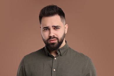 Photo of Portrait of sad man on brown background