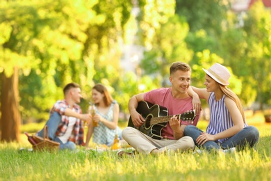 Photo of Young people enjoying picnic in park on summer day