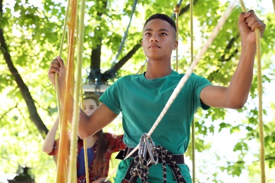 Photo of Children climbing in adventure park. Summer camp