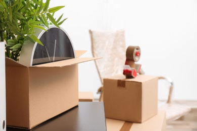 Photo of Moving box with office stuff on table indoors, closeup