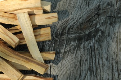 Photo of Palo santo sticks on wooden table, top view. Space for text