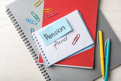Photo of Flat lay composition with words PENSION FUND on white wooden background