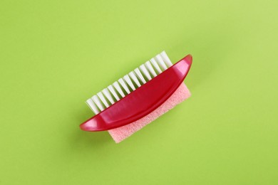 Photo of Pedicure tool with pumice stone and brush on green background, top view
