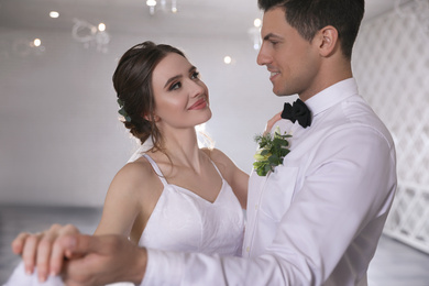 Photo of Happy newlywed couple dancing together in festive hall