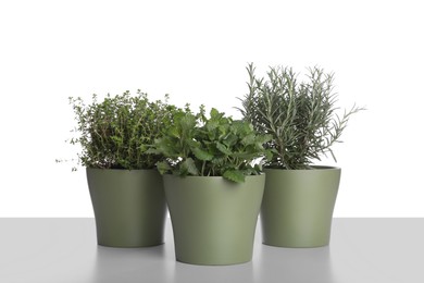Photo of Pots with thyme, mint and rosemary on white background
