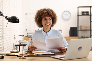 Photo of Happy notary with documents at workplace in office