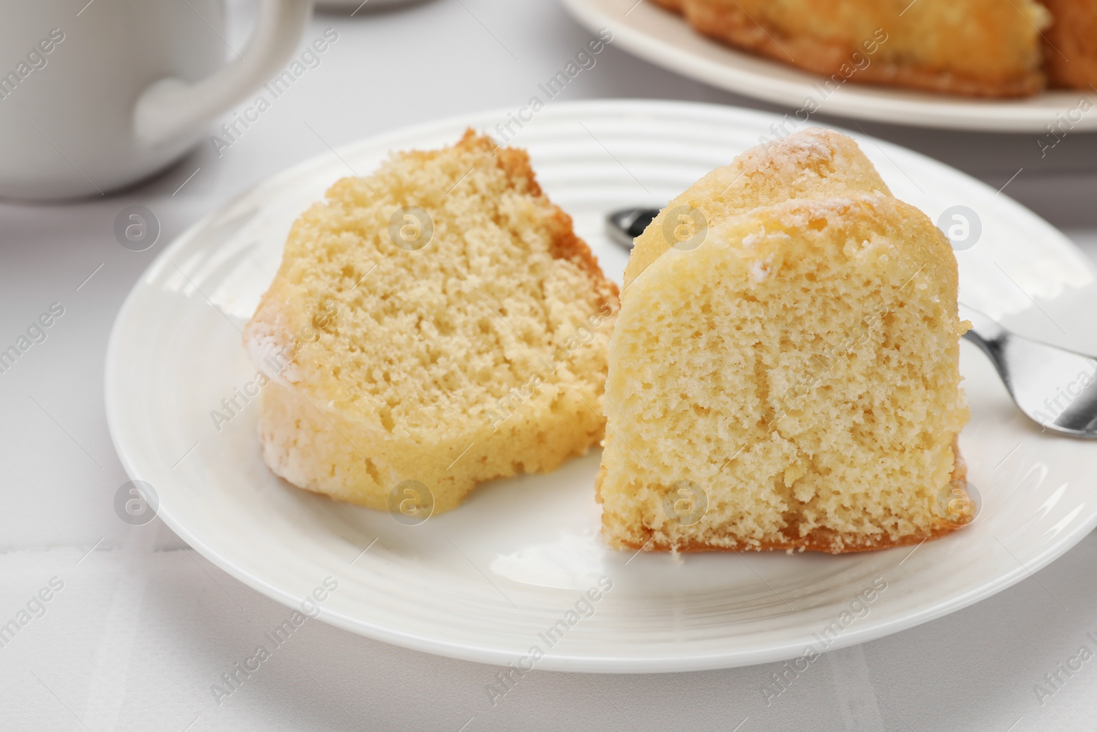 Photo of Pieces of delicious sponge cake on white table, closeup