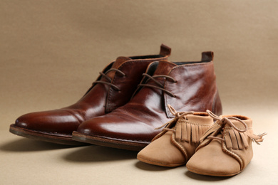 Photo of Dad and son's shoes on beige background. Happy Father's Day