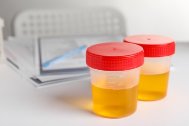 Photo of Containers with urine samples on white table in laboratory, space for text. Specimen collection