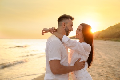 Photo of Happy young couple on beach at sunset