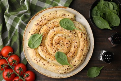 Photo of Delicious puff pastry with spinach on wooden table, flat lay