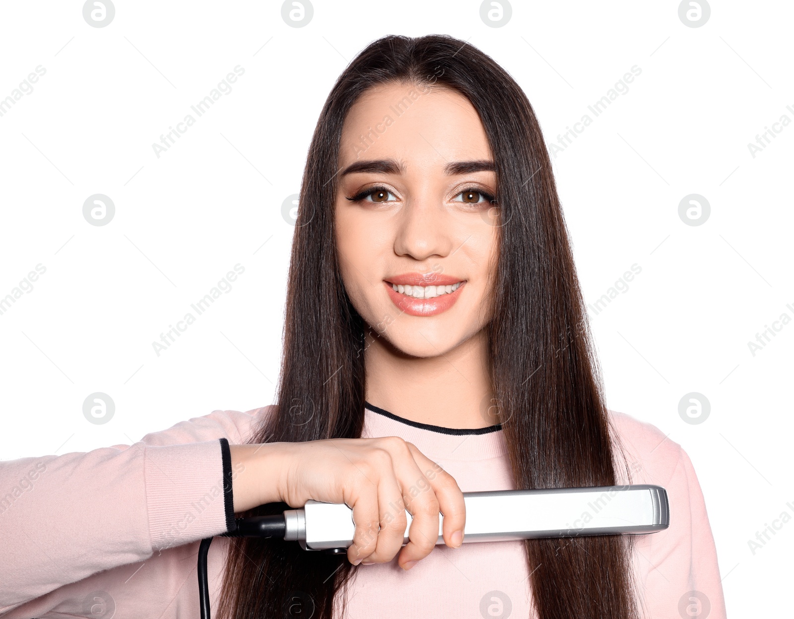 Happy woman using hair iron on white background Photo of Happy woman using hair iron on white background