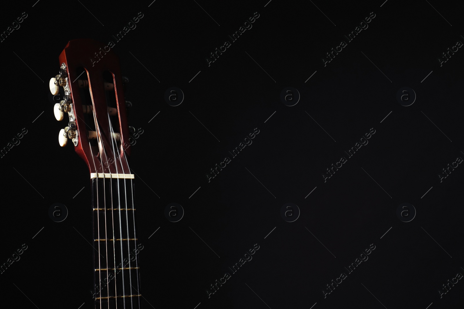 Photo of Acoustic guitar on black background, closeup. Space for text