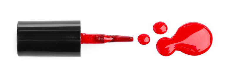 Photo of Brush and spilled red nail polish isolated on white, top view