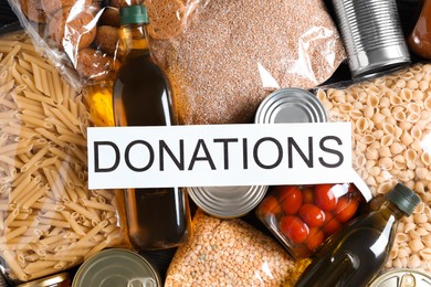 Photo of Card with word Donations on different products, top view