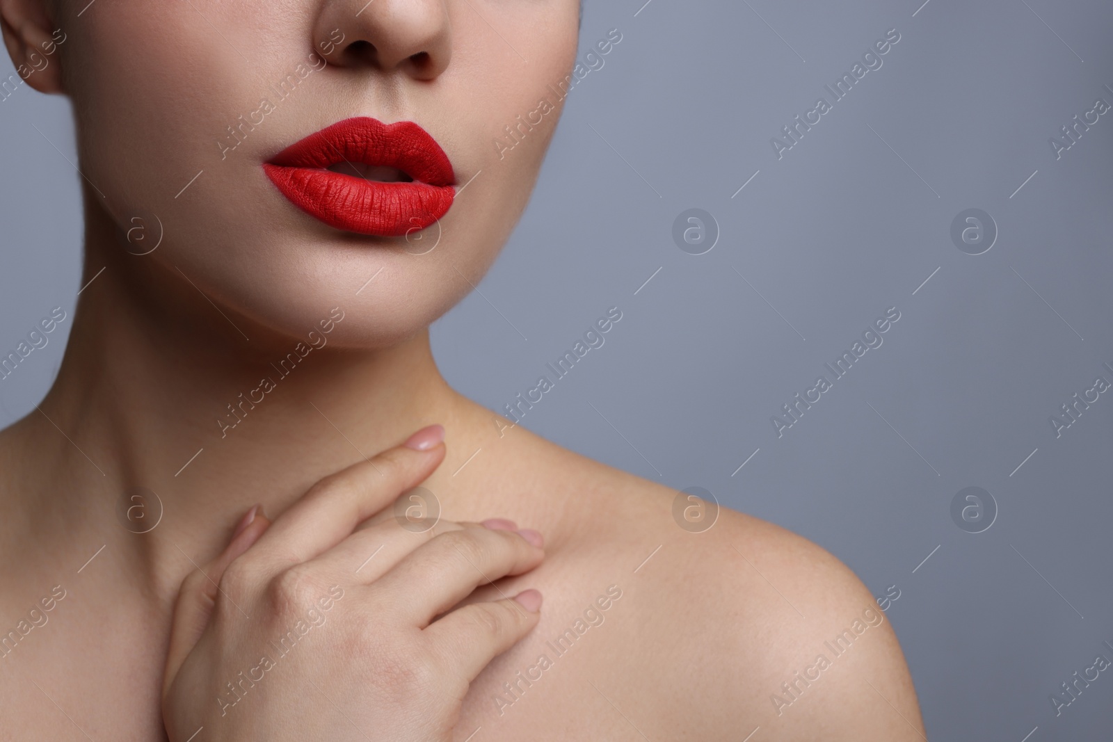 Photo of Closeup view of woman with beautiful full lips on grey background. Space for text