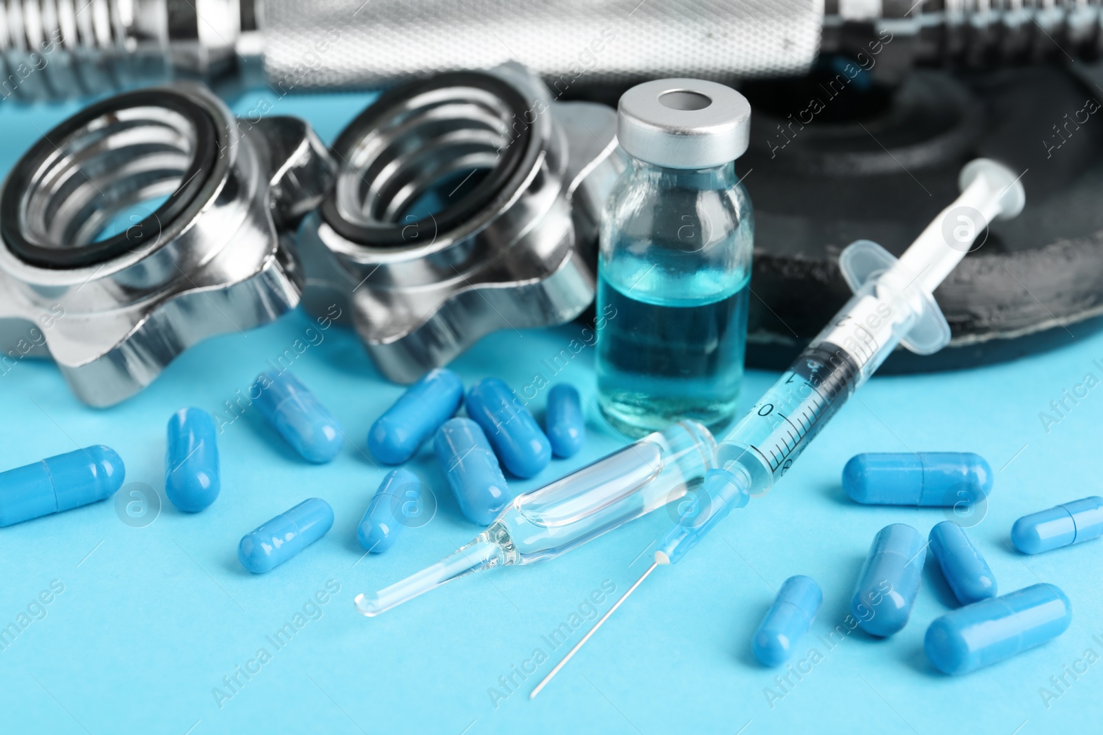 Photo of Different drugs and sports equipment on light blue background. Doping control