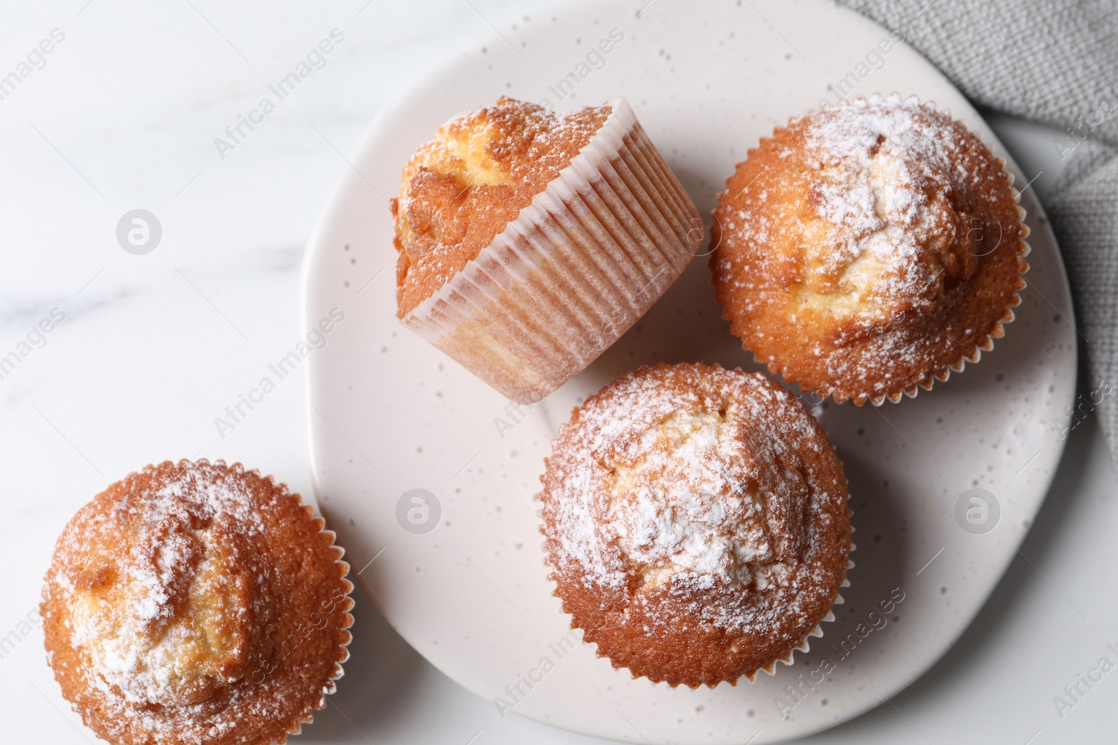 Photo of Delicious sweet muffins on white marble table, flat lay