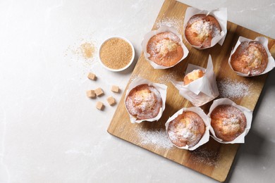 Photo of Delicious muffins on light table, flat lay. Space for text