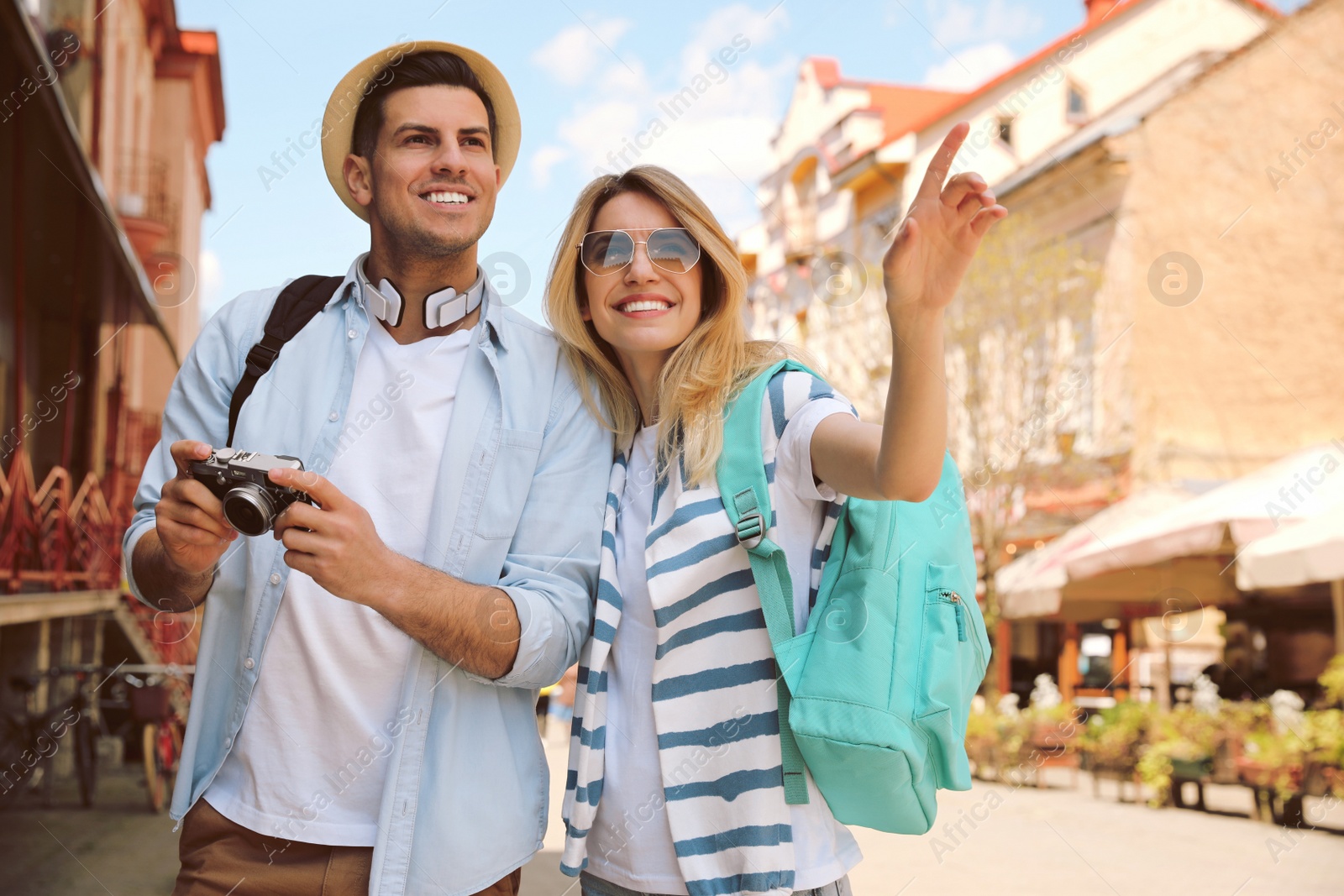 Photo of Happy couple of tourists with camera on city street