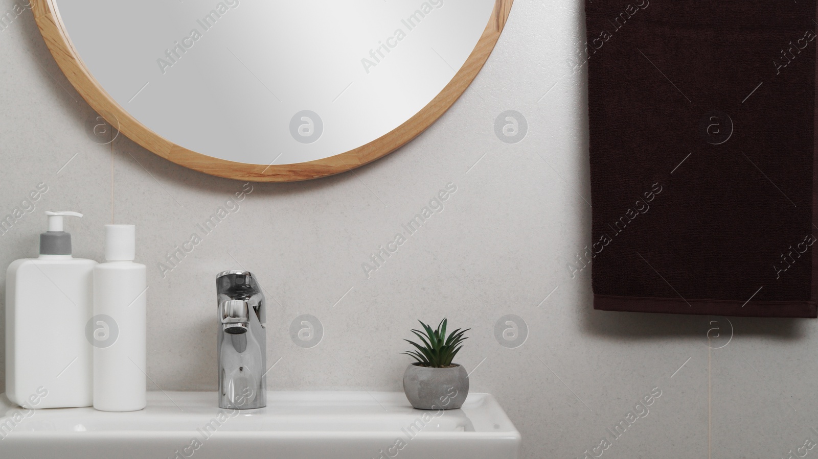 Photo of Brown soft towel hanging on grey wall in bathroom