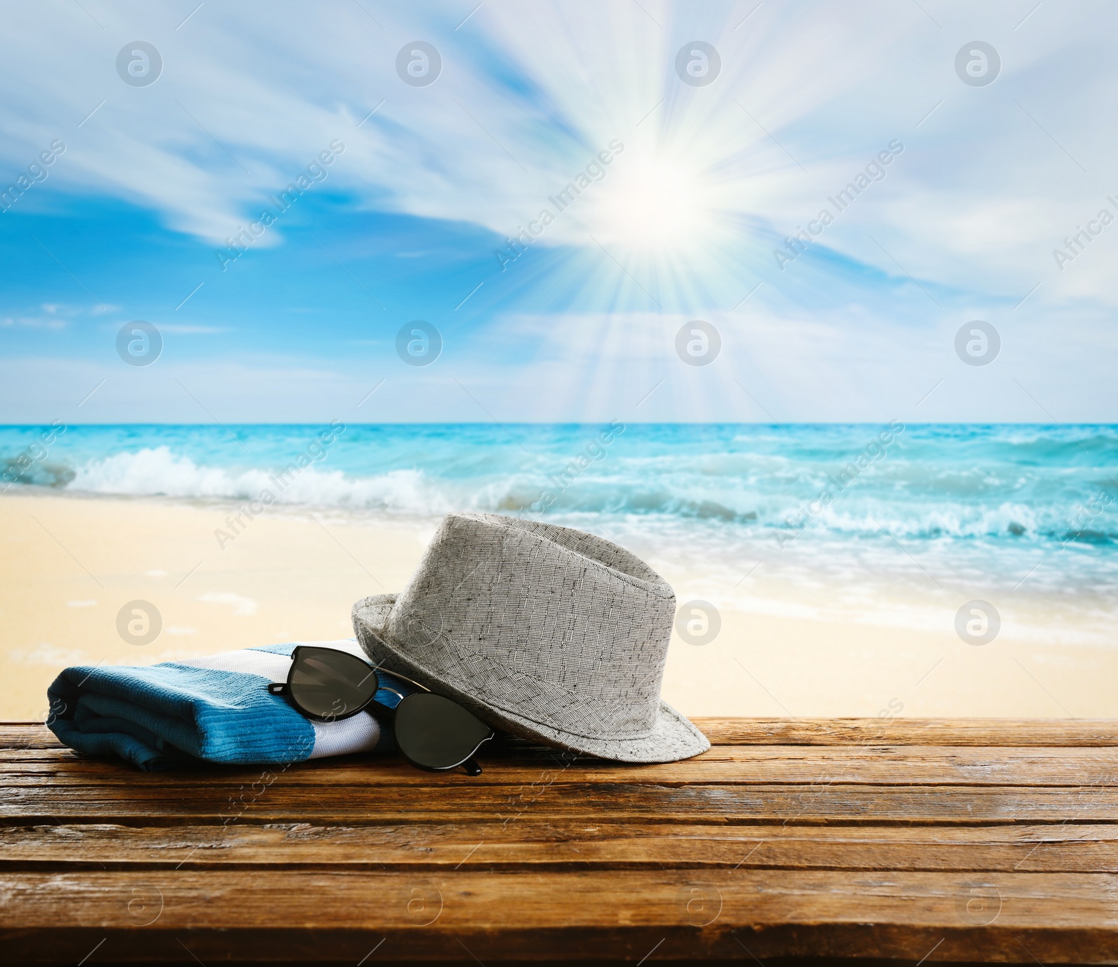 Image of Beach accessories on wooden surface near ocean 