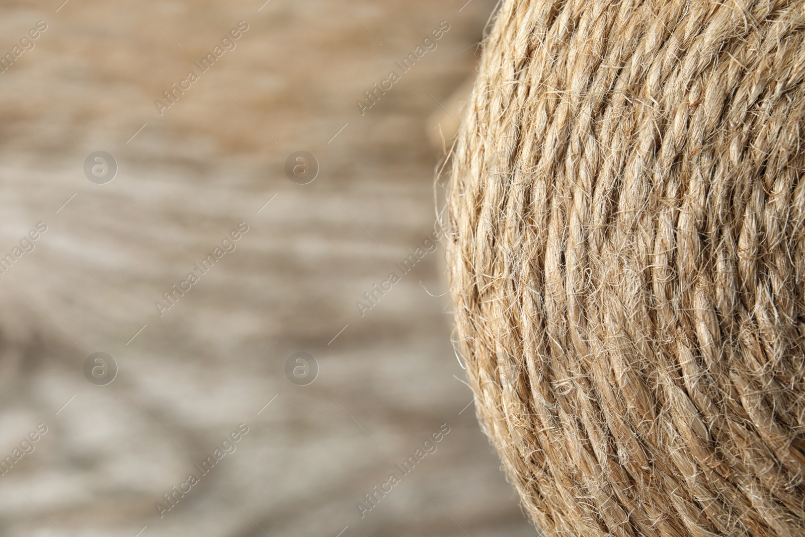 Photo of Spool with hemp rope on blurred background, closeup. Space for text
